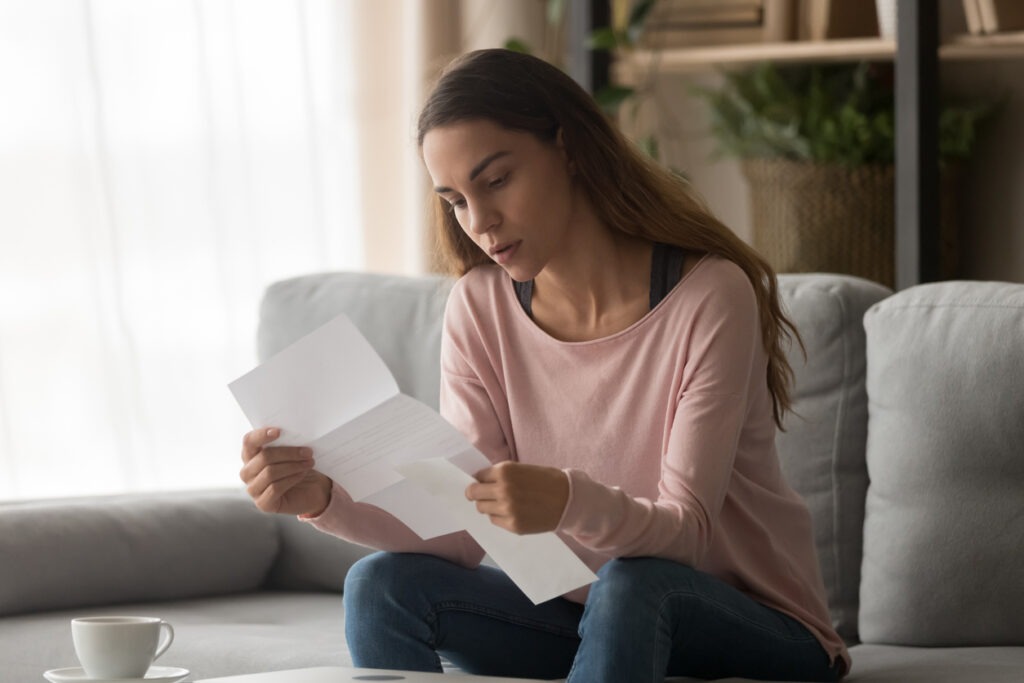 Woman stressed reading disability benefits letter