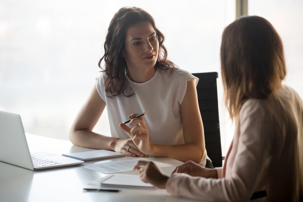 Two women talking during a meeting in an office