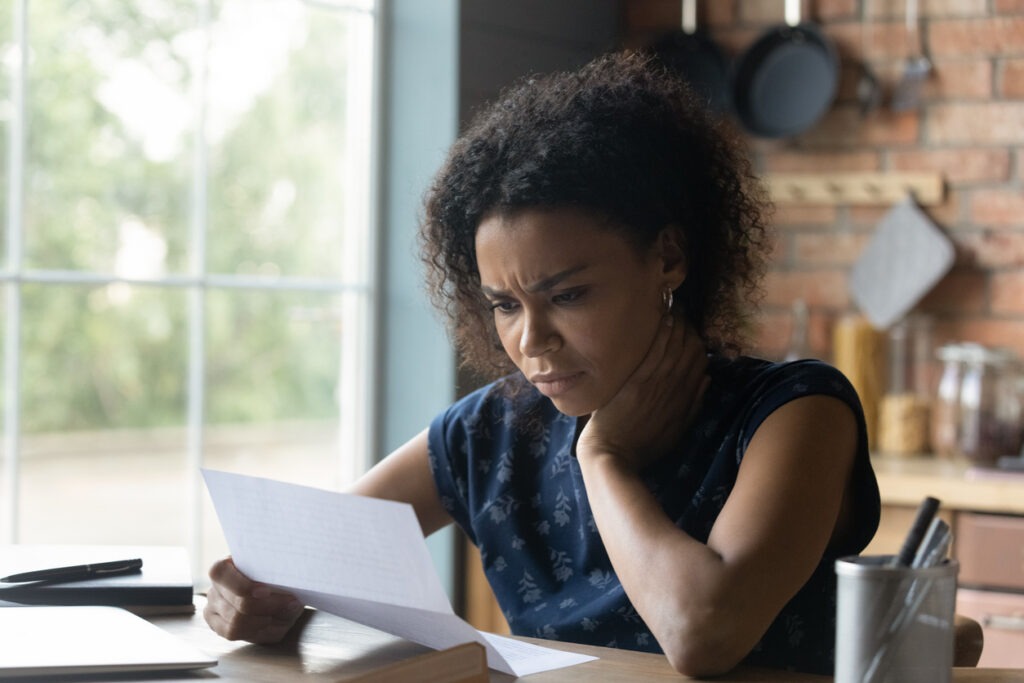 Woman looking stressed while reading rejection letter