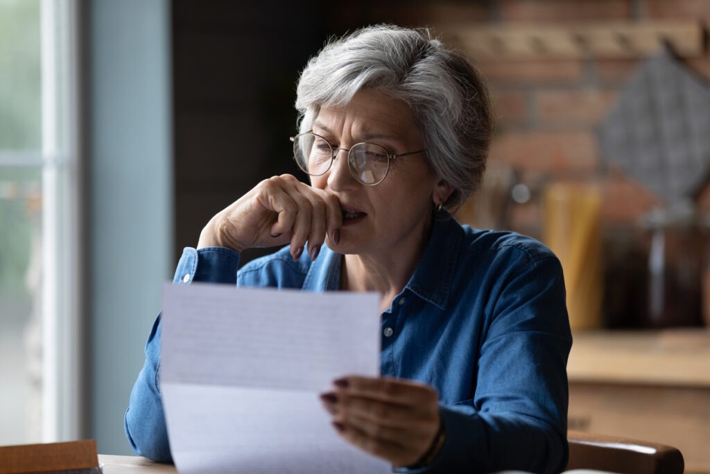 Stressed older latin woman get bad surprise reading official letter stock photo